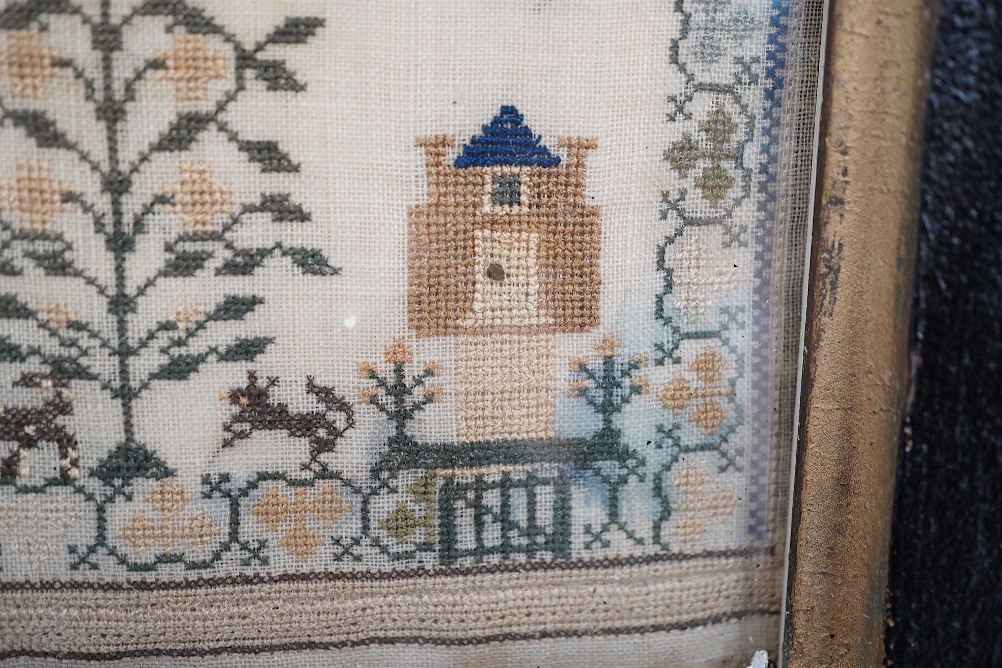 A framed 1835, dated sampler, embroidered by Mary Walker, worked in fine coloured silks, with a central verse and large three storey house, trees, dogs, deer and rabbits, below a panel of embroidered trees, flowers and b